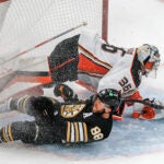 Boston Bruins right wing David Pastrnak slides into Anaheim Ducks goaltender John Gibson during second period NHL action at TD Garden.