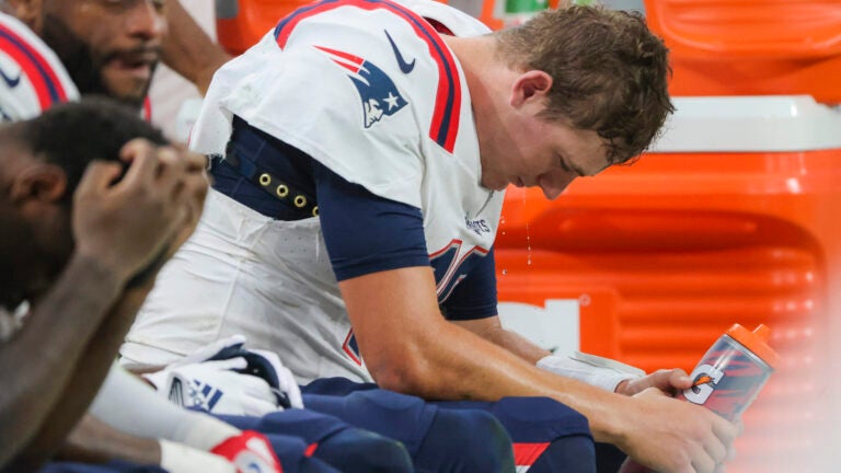 New England Patriots quarterback Mac Jones sitting on the bench after getting sacked for a saftey against the Las Vegas Raiders during fourth quarter NFL action at Allegiant Stadium.