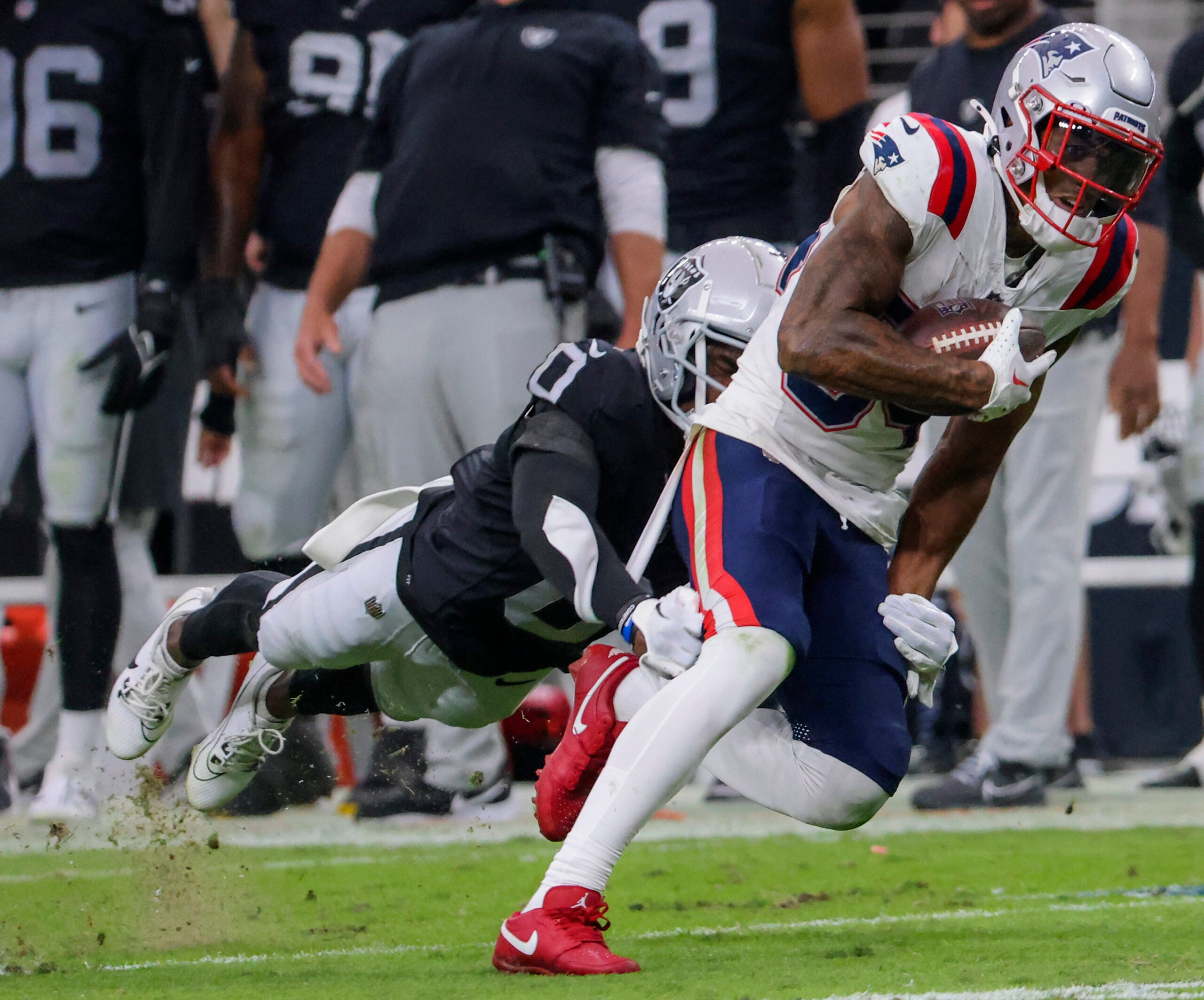 New England Patriots Kendrick Bourne is tackled by Las Vegas Raiders Jakorian Bennett.