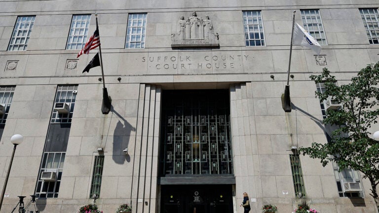 The front of a grey building in Boston with "Suffolk County Courthouse" engraved above its doors.