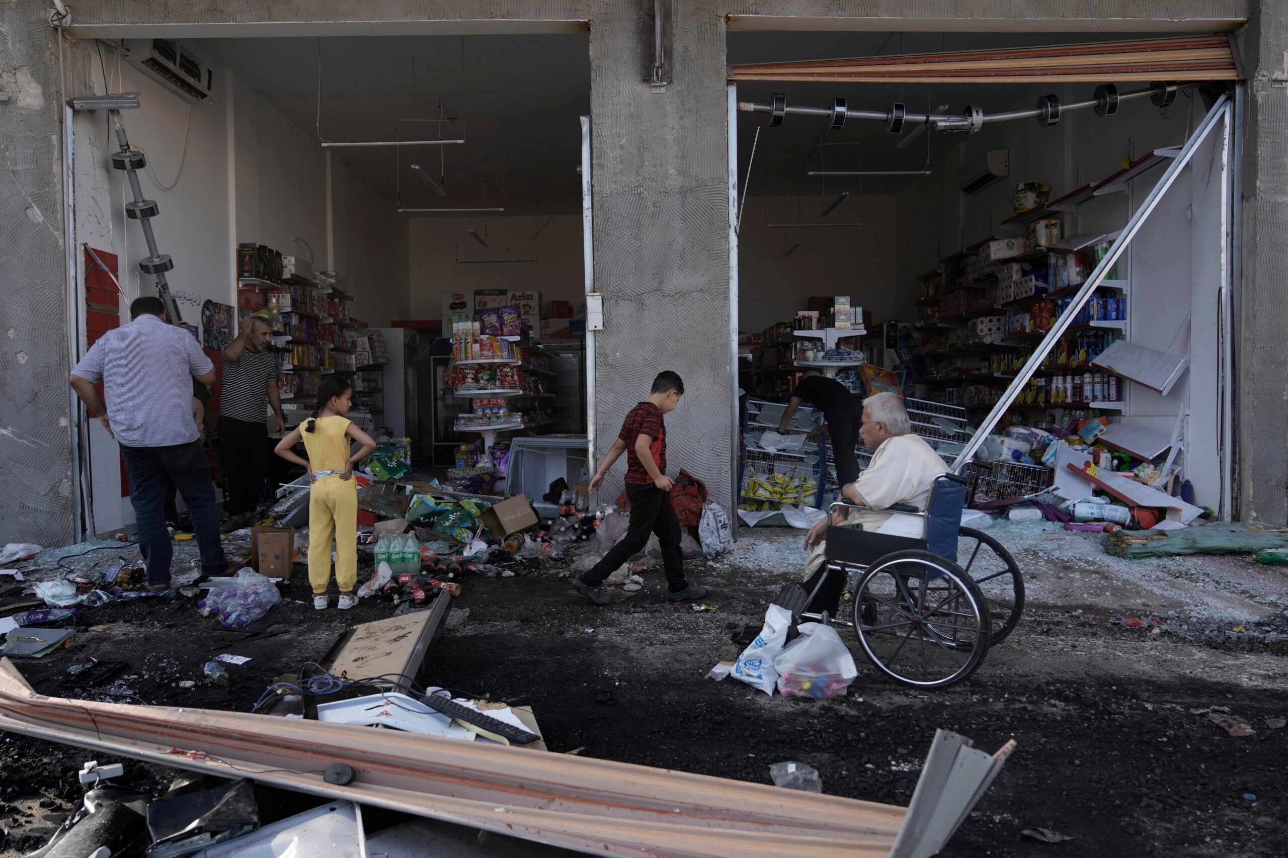 Palestinians look at the damage after an Israeli army raid. 