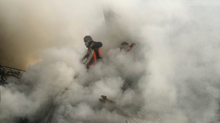 Palestinian firefighters extinguish fire caused by an Israeli airstrike in Khan Younis refugee camp.