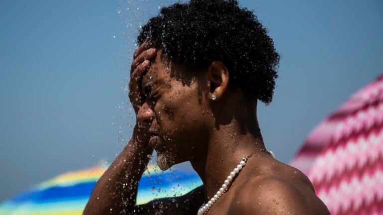 A man cools off in a shower at Ipanema beach, Rio de Janeiro, Brazil.