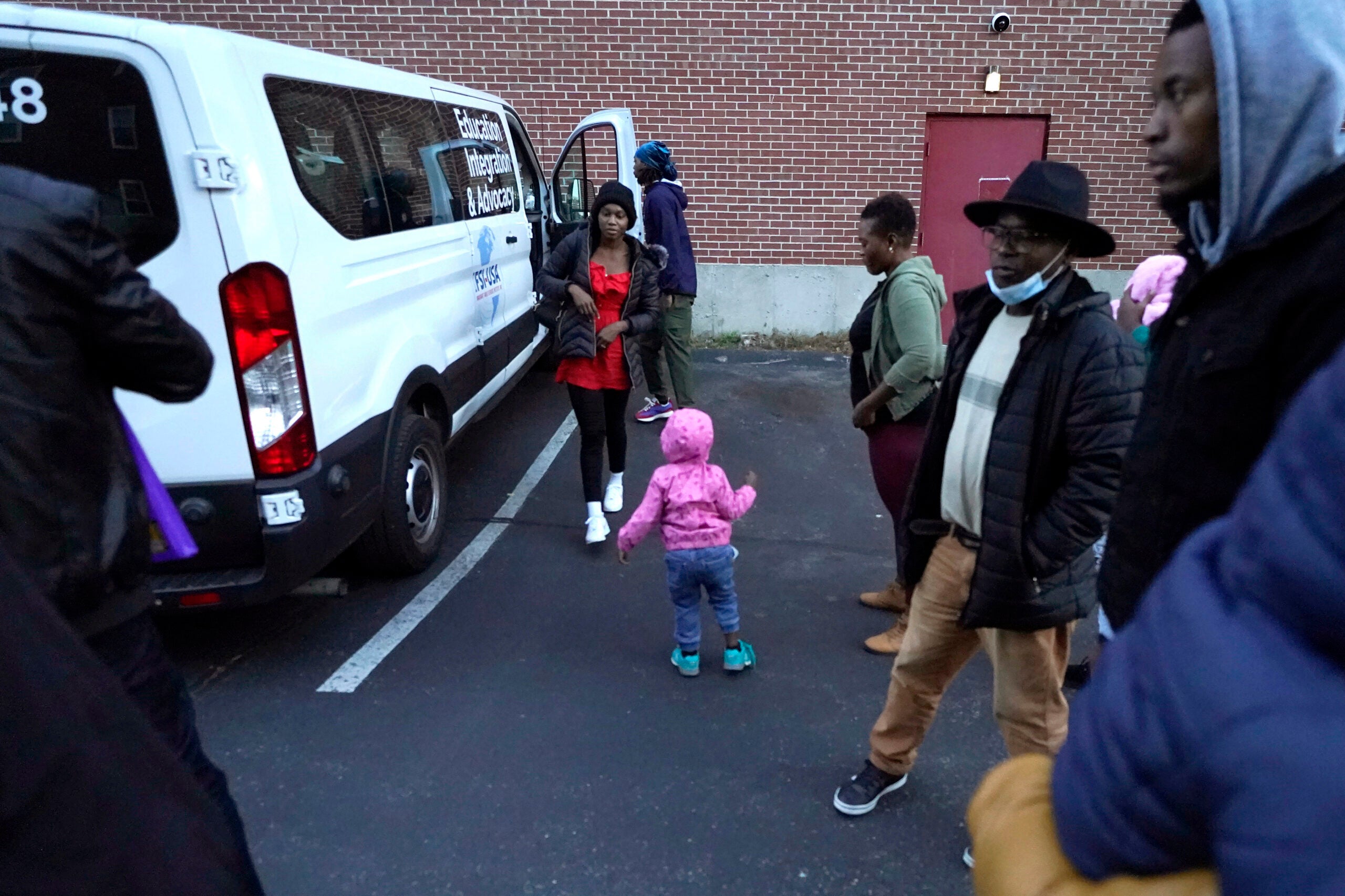 Haitian immigrants step out of a van as they arrive at a shelter in Quincy. 