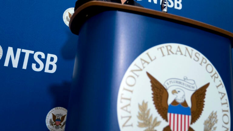 The National Transportation Safety Board logo and signage are seen at a news conference at NTSB headquarters in Washington.