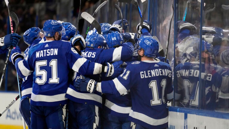 Tampa Bay Lightning players mob left wing Brandon Hagel after he scored the game-winning goal against the Boston Bruins in overtime an NHL hockey game Monday, Nov. 20, 2023, in Tampa, Fla.
