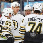 Boston Bruins defenseman Hampus Lindholm celebrates his goal with Brad Marchand (63) and Jake DeBrusk (74) during the second period of an NHL hockey game against the Buffalo Sabres, Tuesday, Nov. 14, 2023, in Buffalo N.Y.