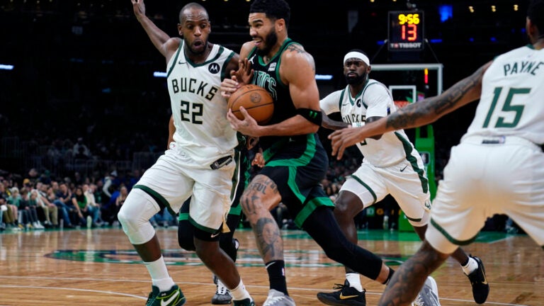 Celtics forward Jayson Tatum drives to the basket against Milwaukee Bucks forward Khris Middleton during the first half.