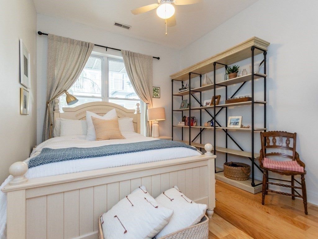 Bedroom with a white bed frame, and wood flooring. 