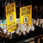 Players on the 1970 and 1972 Stanley Cup-champion Boston Bruins teams raise banners before the Bruins' NHL hockey game against the Montreal Canadiens, as part of the team's season-long centennial celebrations Saturday, Nov. 18, 2023, in Boston.