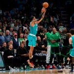Charlotte Hornets forward Miles Bridges, left, shoots the ball for a score under pressure from Boston Celtics guard Jrue Holiday during overtime
