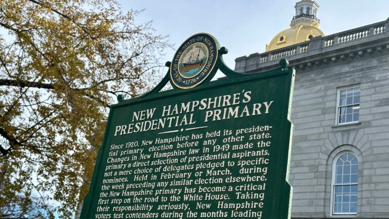 A dark green historical marker displayed outside the Statehouse in Concord, New Hampshire.