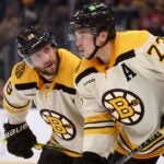BOSTON, MASSACHUSETTS - NOVEMBER 18: Pavel Zacha #18 of the Boston Bruins talks with Charlie McAvoy #73 during the second period against the Montreal Canadiens at TD Garden on November 18, 2023 in Boston, Massachusetts.