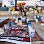 Flowers and candles are left at a makeshift shrine.