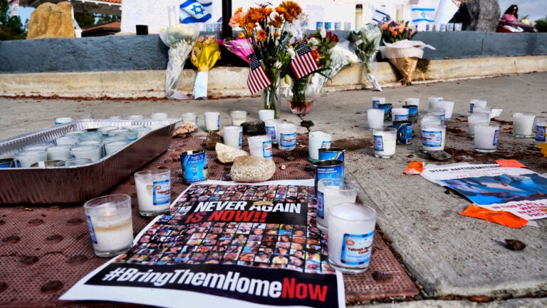 Flowers and candles are left at a makeshift shrine.