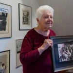 Peggy Simpson holds a photograph of law enforcement carrying Lee Harvey Oswald's gun through a hallway packed with reporters.