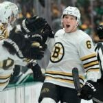 DALLAS, TEXAS - NOVEMBER 06: Mason Lohrei #6 of the Boston Bruins is congratulated by his bench after scoring his first career NHL goal during the first period against the Dallas Stars at American Airlines Center on November 06, 2023 in Dallas, Texas.