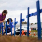 Lucy Allard, 5, and her brother Zeke Allard, 8, plant crosses in honor of the victims of this week's mass shooting in Lewiston, Maine.