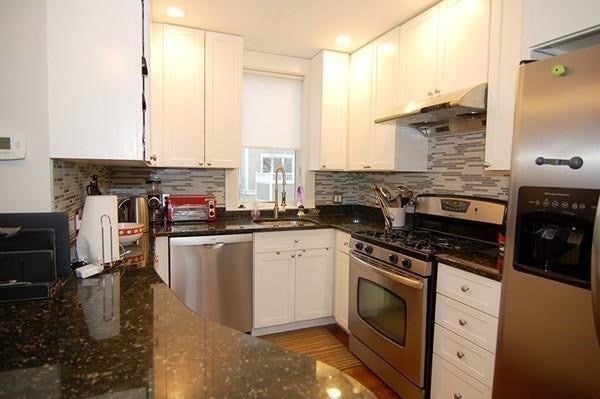 Kitchen with white cabinets and stainless steel appliances. 