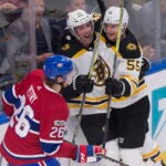 Boston Bruins forward Tim Schaller (59) is congratulated by forward Noel Acciari after he scored as Montreal Canadiens Jeff Petry skates by during the second period of a preseason NHL hockey game, Monday, Sept. 18, 2017, in Quebec City, Quebec.
