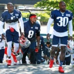 Back for his second tour with the Patriots, linebacker Jamie Collins, Sr. was sporting the number 8 and was surrounded by the McCourty twins Devin (left) and Jason (right) as they all climbed the stairs and headed for the practice field. The New England Patriots held their first workout of Training Camp as they prepared to defend their Super Bowl title.