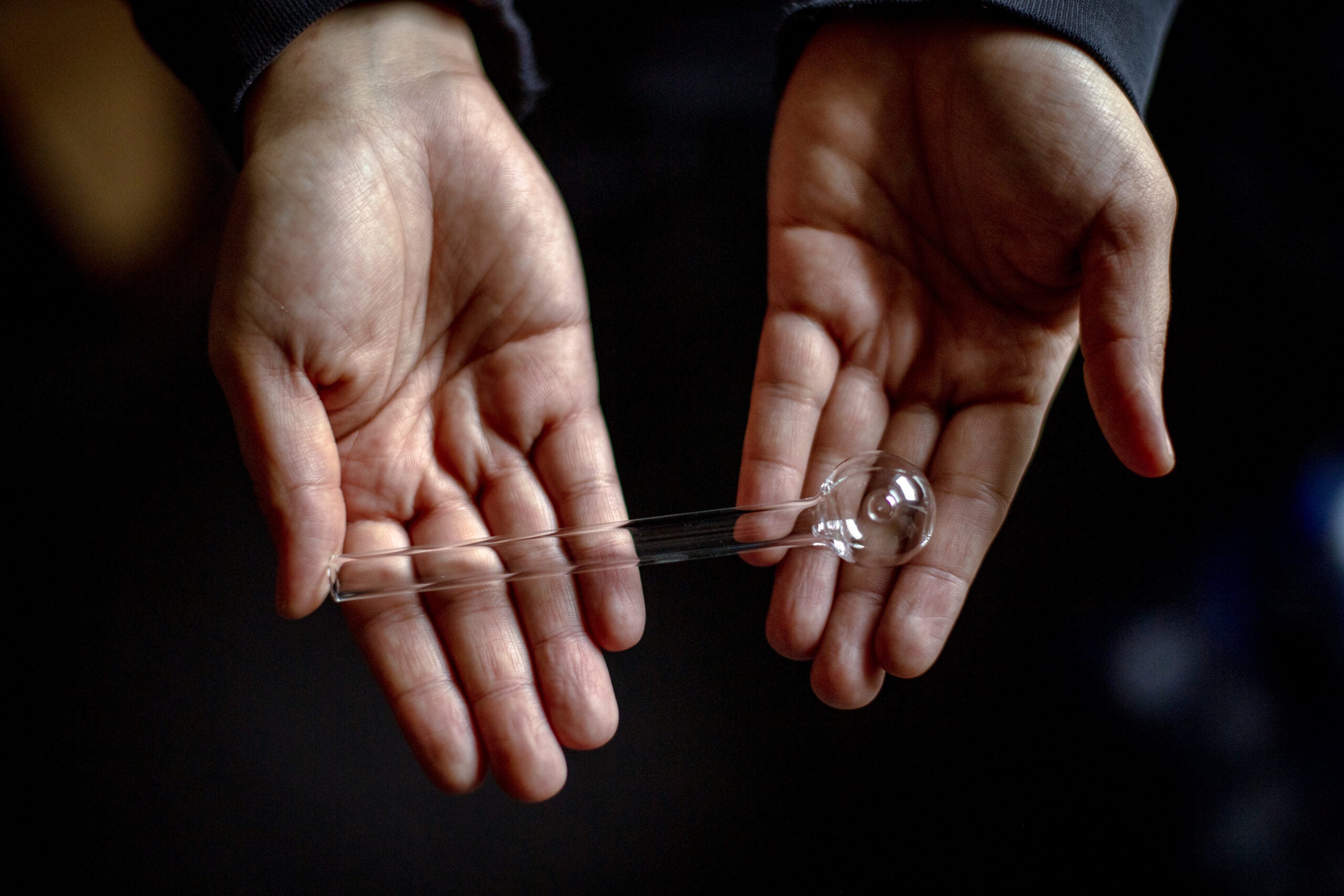 A woman holds a new bubble, the glass pipe used for smoking meth. 