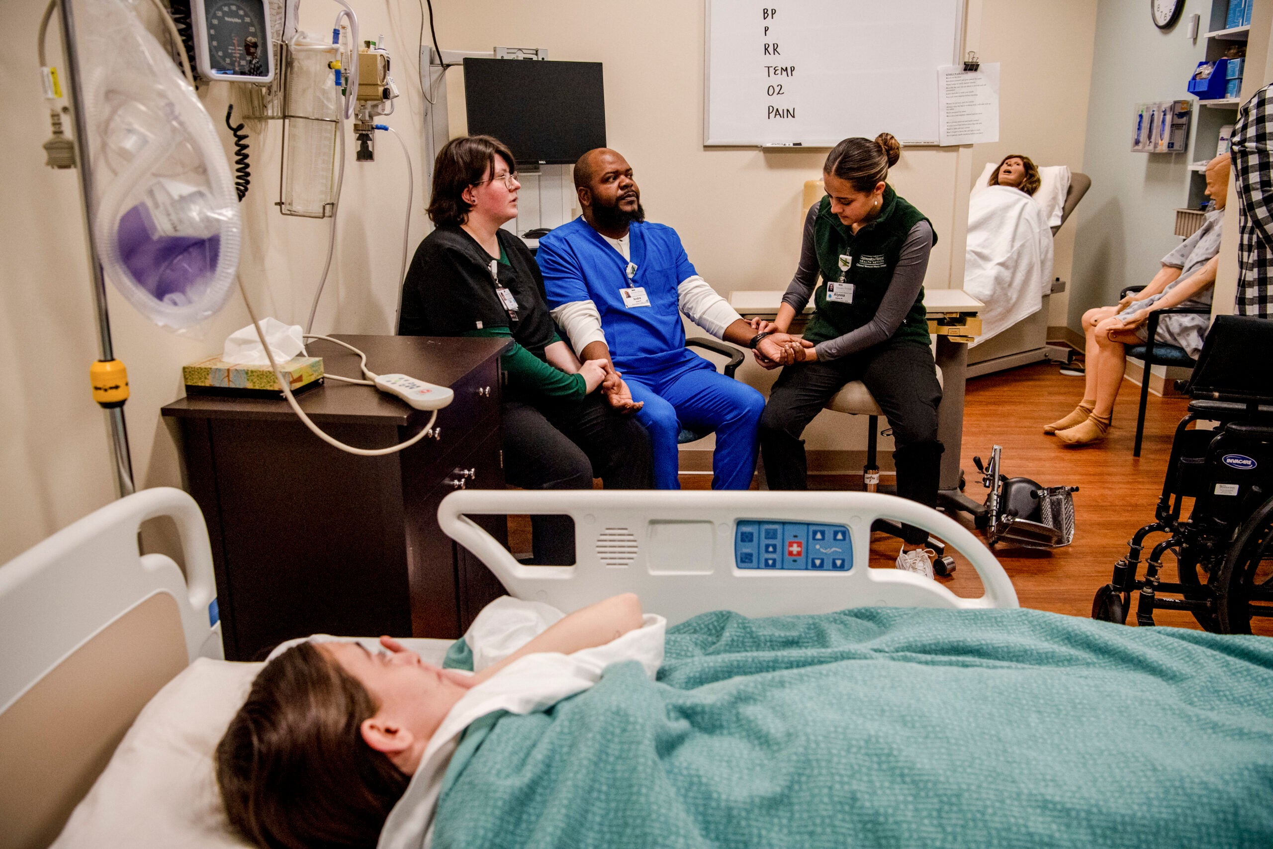 From left, Cal Hobbs, Andre Roberts and Alyssa Winkler practice taking Andre's blood pressure in a simulation lab at the Central Vermont Medical Center in Berlin, Vt.