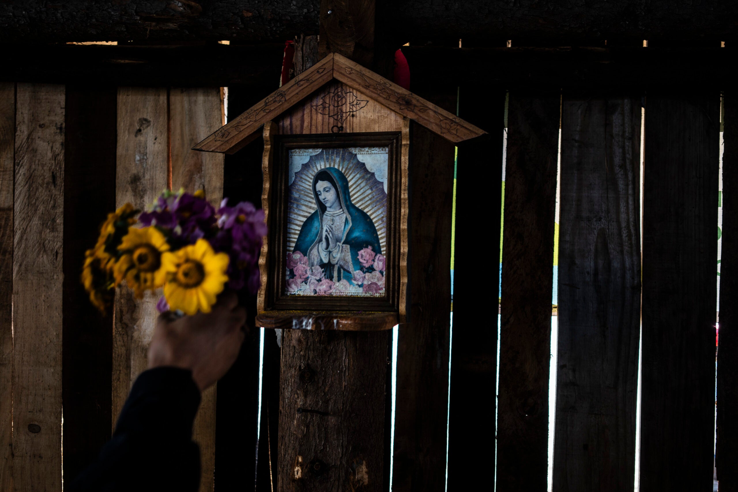 An unidentified environmental activist places flowers on an image of the Virgin of Guadalupe in the state of Michoacán, Mexico. 