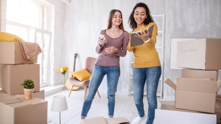 Two roommates looking at a book together.