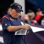 New England Patriots head coach Bill Belichick studies game photos during the third quarter. The New England Patriots host the Washington Commanders on November 5, 2023 at Gillette Stadium in Foxboro, MA.