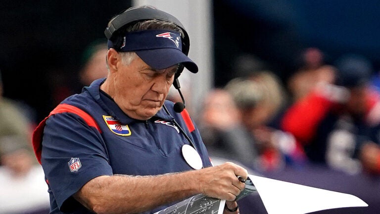 New England Patriots head coach Bill Belichick studies game photos during the third quarter. The New England Patriots host the Washington Commanders on November 5, 2023 at Gillette Stadium in Foxboro, MA.
