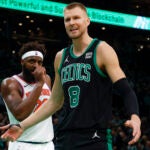 Boston Celtics center Kristaps Porzingis (8) reacting after blocking New York Knicks forward Julius Randle (30) shot during fourth quarter NBA action at TD Garden.