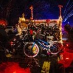 Around 50 bikes are loaded in a trailer and the back of a pickup truck.