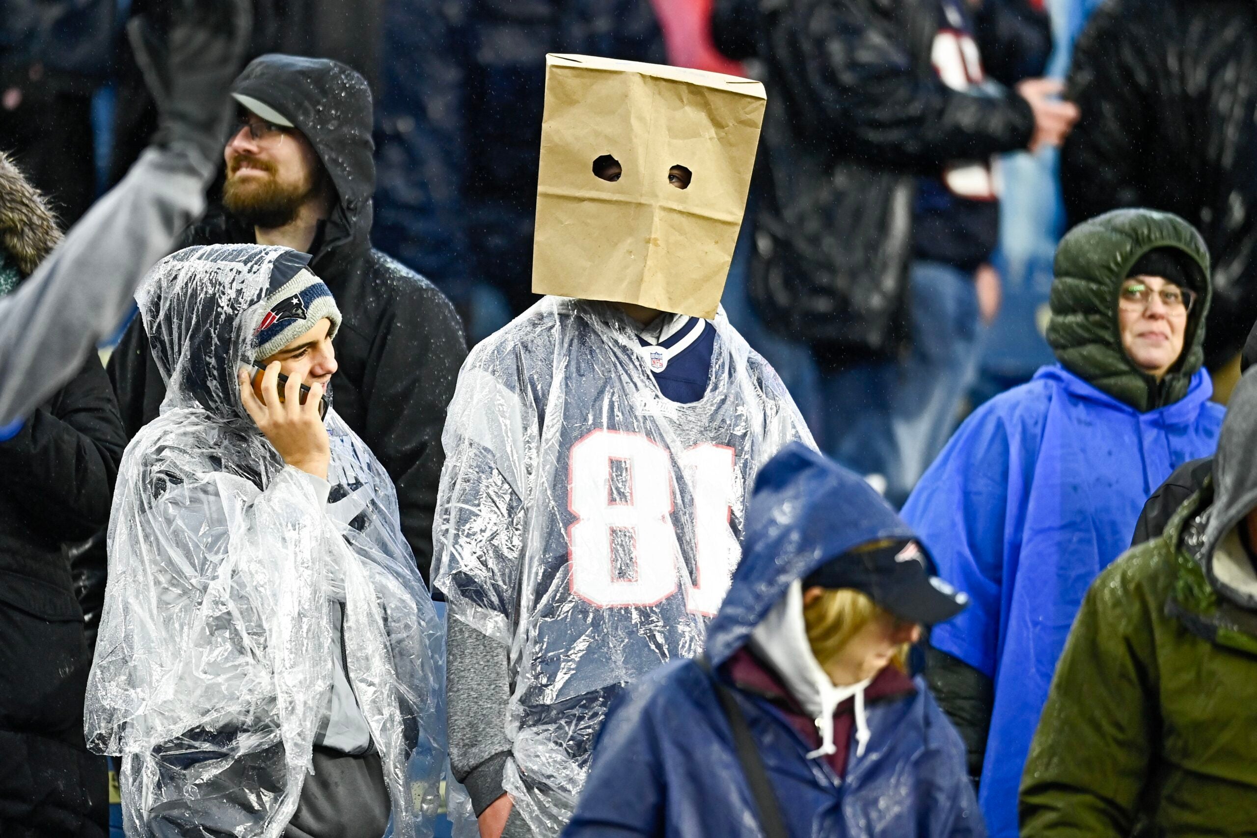 FOXBOROUGH, MASSACHUSETTS - DECEMBER 03: A New England Patriots fan wearing a paper bag looks on during the game between the Los Angeles Chargers and the New England Patriots at Gillette Stadium on December 03, 2023 in Foxborough, Massachusetts.