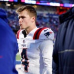 New England Patriots quarterback Bailey Zappe (4) walks off the field after falling to the Buffalo Bills, 27-21, at Highmark Stadium.
