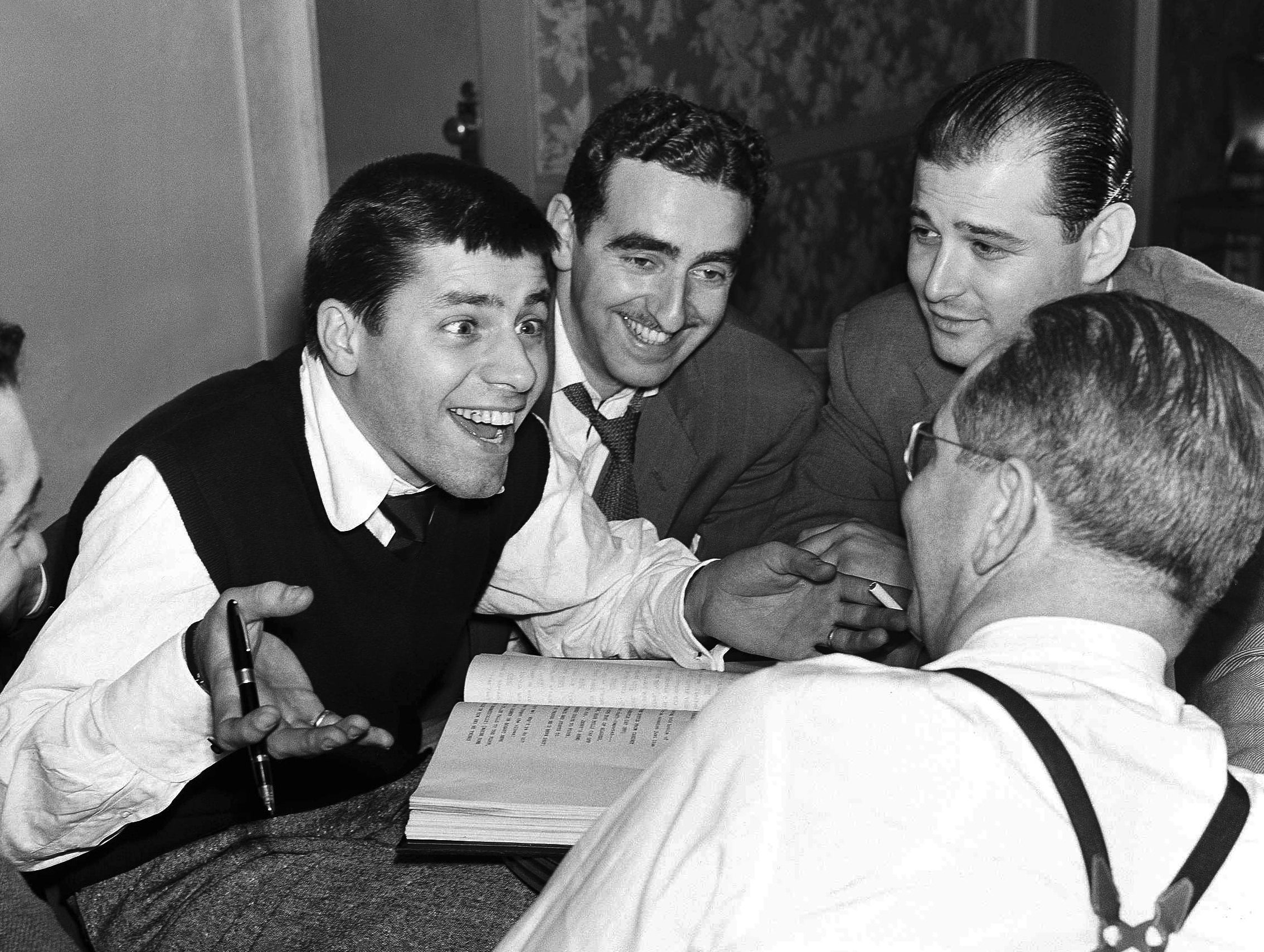 Comedian Jerry Lewis, left, meets with Ed Simmons, center, writer Norman Lear, background right, and producer Ernie Glucksman. 