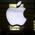 FILE - The Apple logo is illuminated at a store in the city center of Munich, Germany, Dec. 16, 2020.