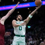 Celtics forward Jayson Tatum shoots at the basket as Cleveland Cavaliers forward Dean Wade defends in the first half.
