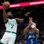 Celtics guard Jaylen Brown shoots over Orlando Magic forward Paolo Banchero during the first half.