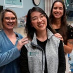 Andy Hoang, a recent nursing graduate, center, poses with co-workers Lisa Davenport, left, and Justina Terino.