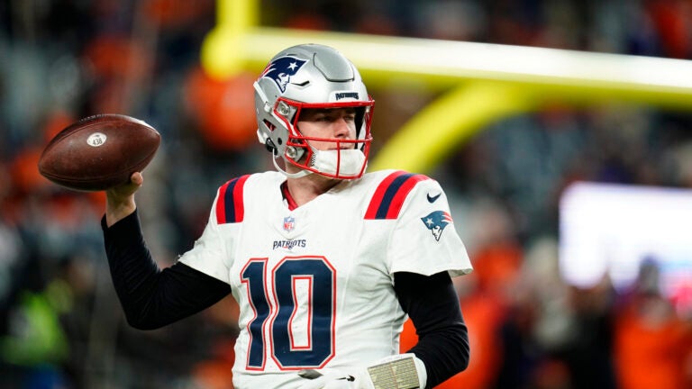 New England Patriots quarterback Mac Jones (10) throws during pregame of an NFL football game against the Denver Broncos, Sunday, Dec. 24, 2023, in Denver.