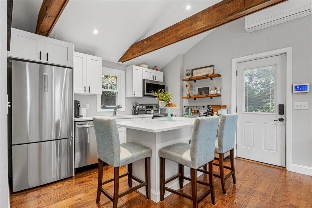 Kitchen with white cabinets and wood flooring. 