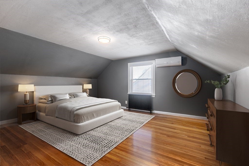 Bedroom with gray walls and wooden floors.