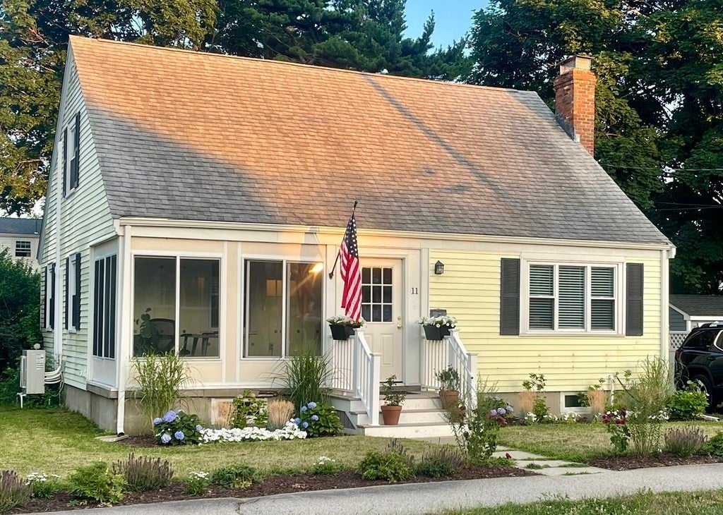 Home in Quincy with yellow siding and an American Flag. 