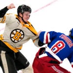 Boston Bruins center Trent Frederic, left, fights New York Rangers defenseman Jacob Trouba (8) during the second period of an NHL hockey game, Saturday, Dec. 16, 2023, in Boston.