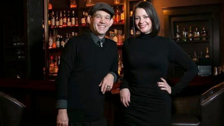 Todd and Victoria Horvath pose for a photo inside their new bar, The Hidden Door.