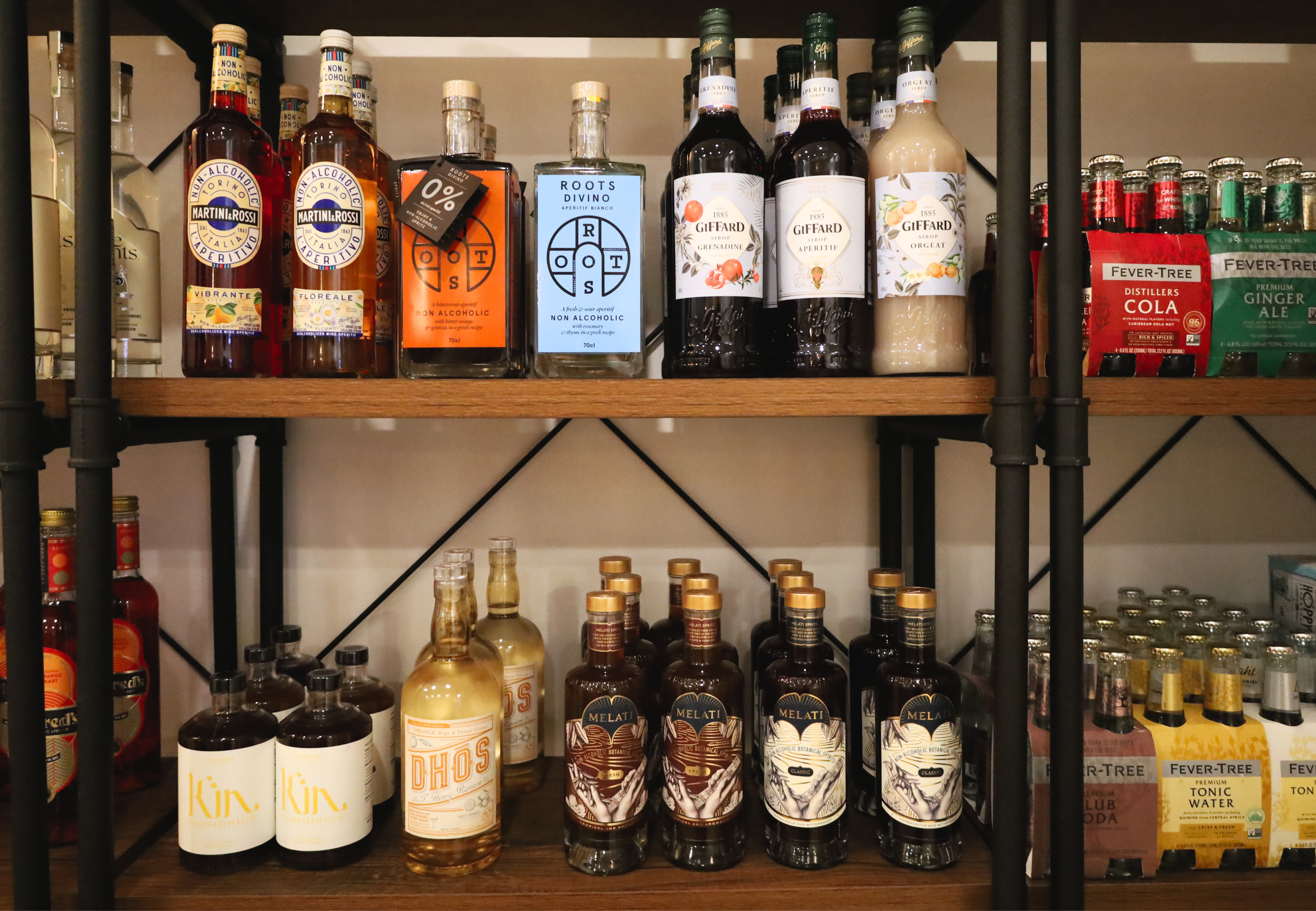 Shelves containing multiple bottles of non-alcoholic liquor.