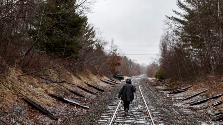 Tammy Lacher Scully walks along railroad tracks.