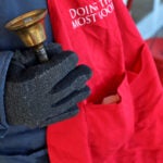 A Salvation Army volunteer holds a bell during a Red Kettle campaign.
