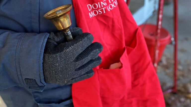 A Salvation Army volunteer holds a bell during a Red Kettle campaign.